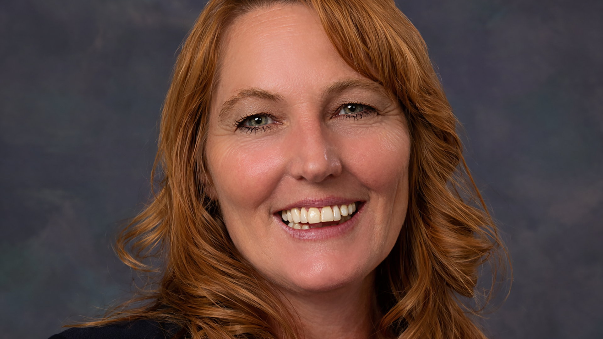 A woman with red hair smiling